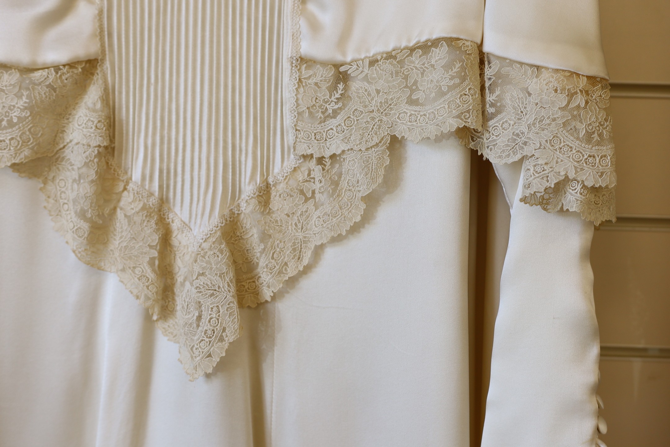 A 1970's cream satin wedding dress, trimmed with 19th century point de gaze, hand made needlepoint lace